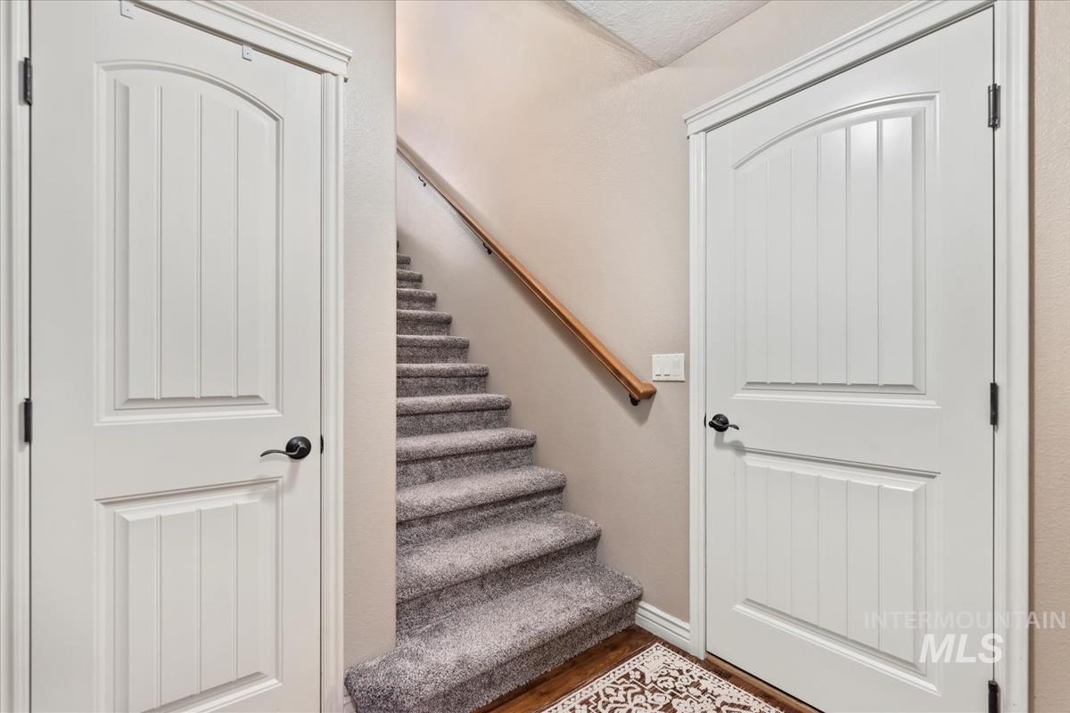 Staircase with wood finished floors and baseboards