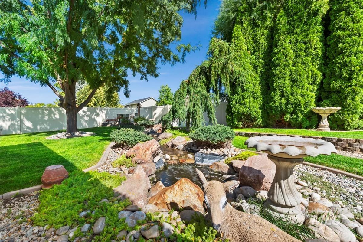 Fenced backyard featuring a small pond