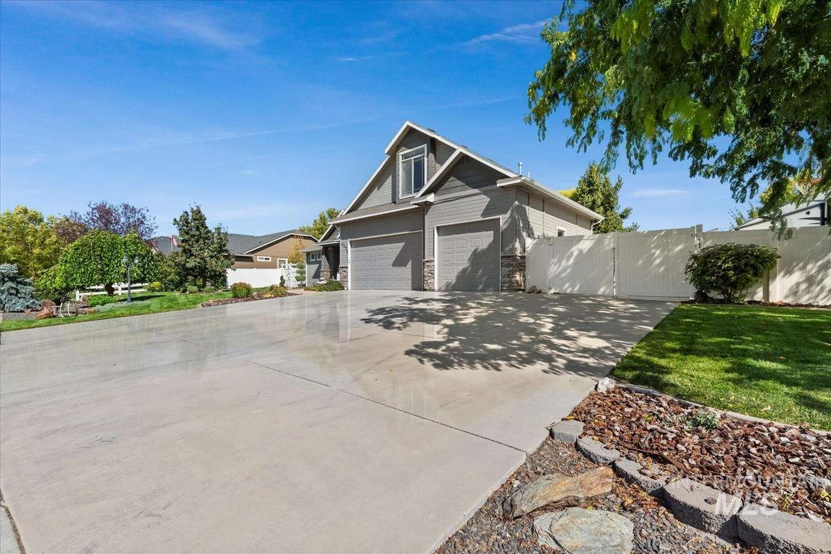 View of front facade with concrete driveway and stone siding