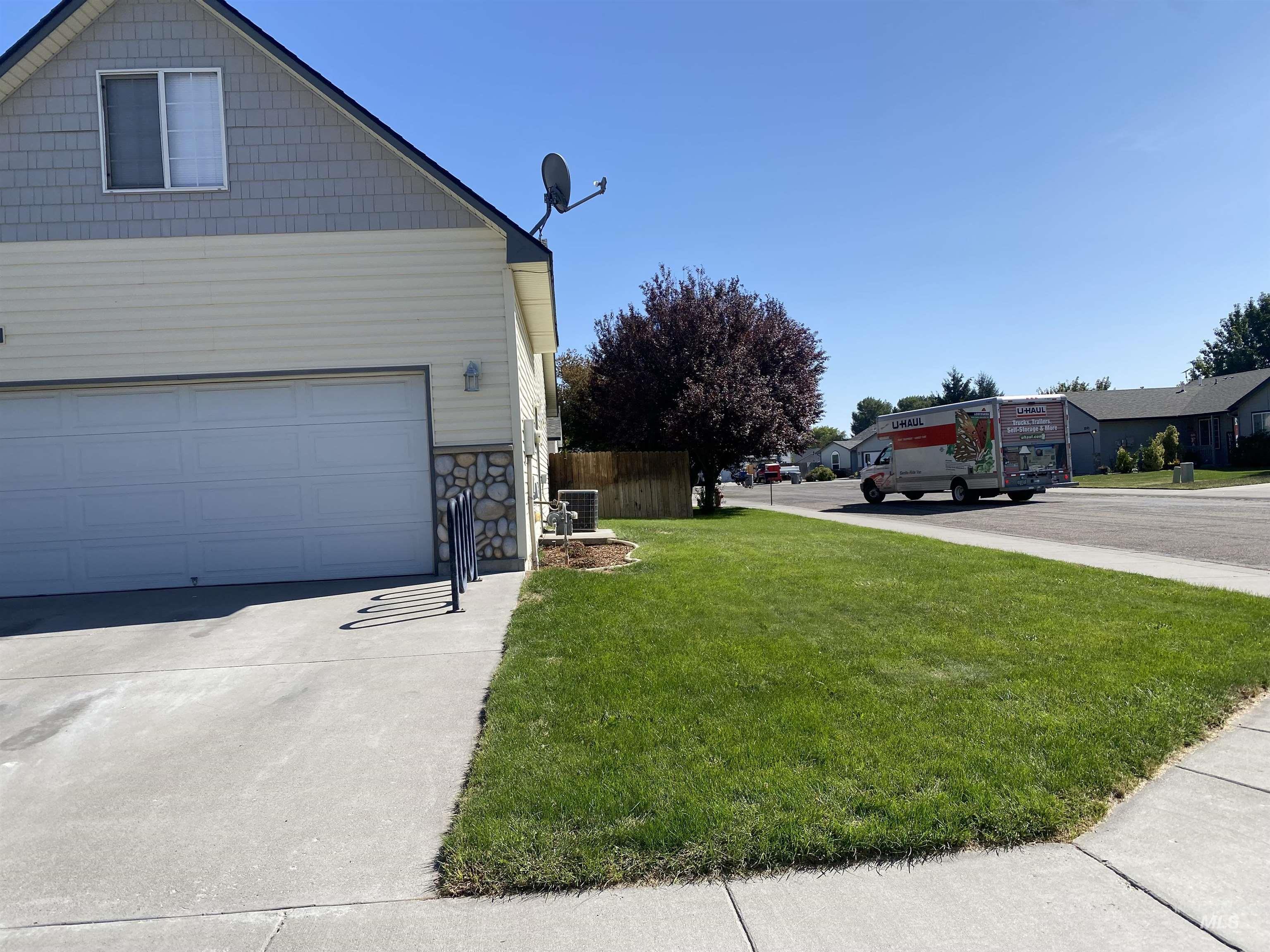 View of side of property with stone siding, a garage, and concrete driveway