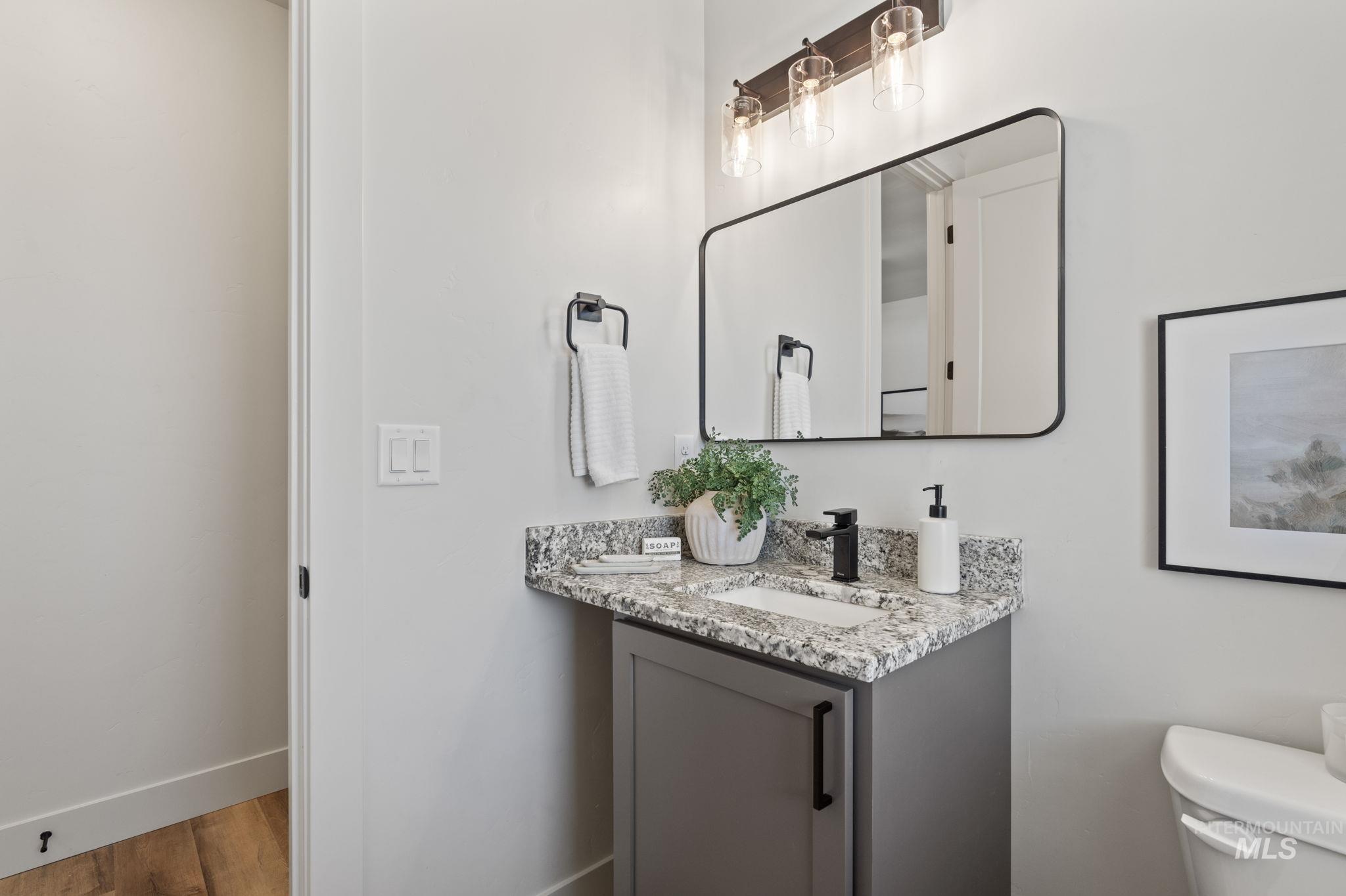 Bathroom with double vanity and wood finished floors