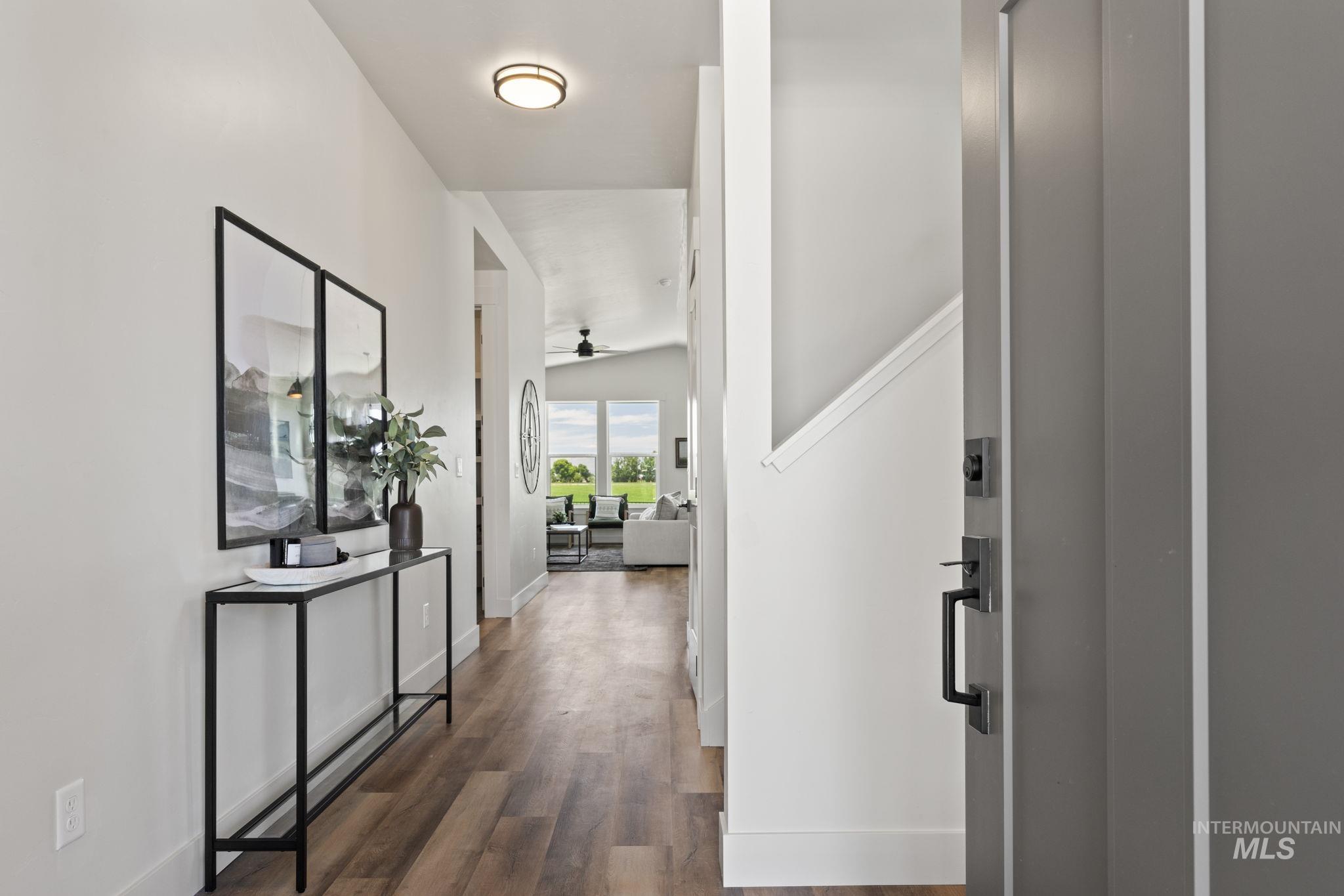 Hallway featuring dark wood-style flooring and baseboards