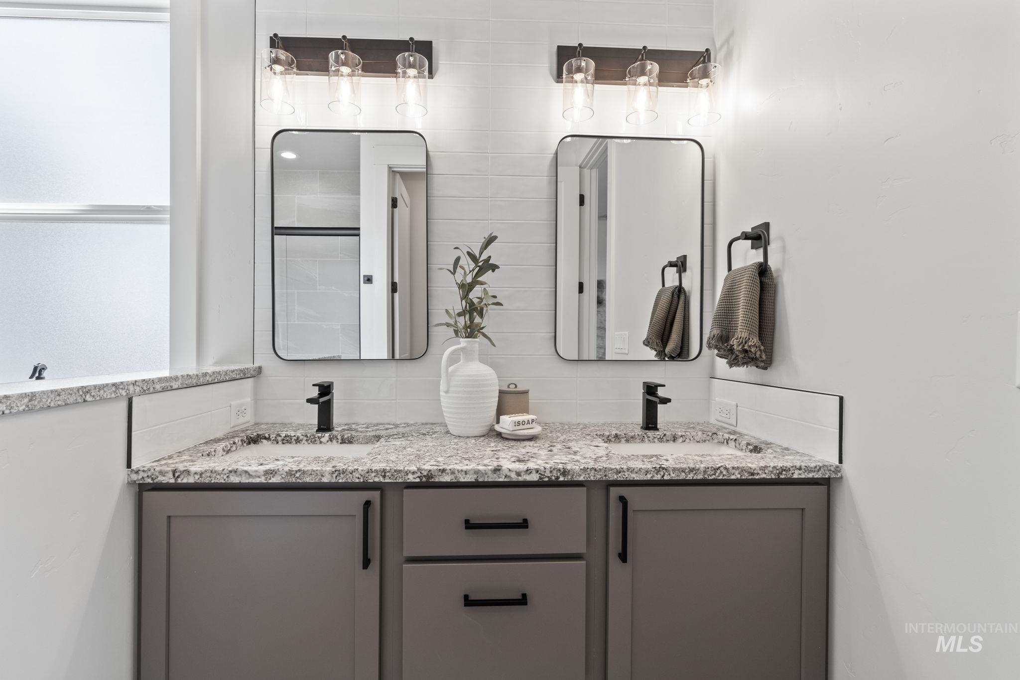 Bathroom with double vanity and tasteful backsplash
