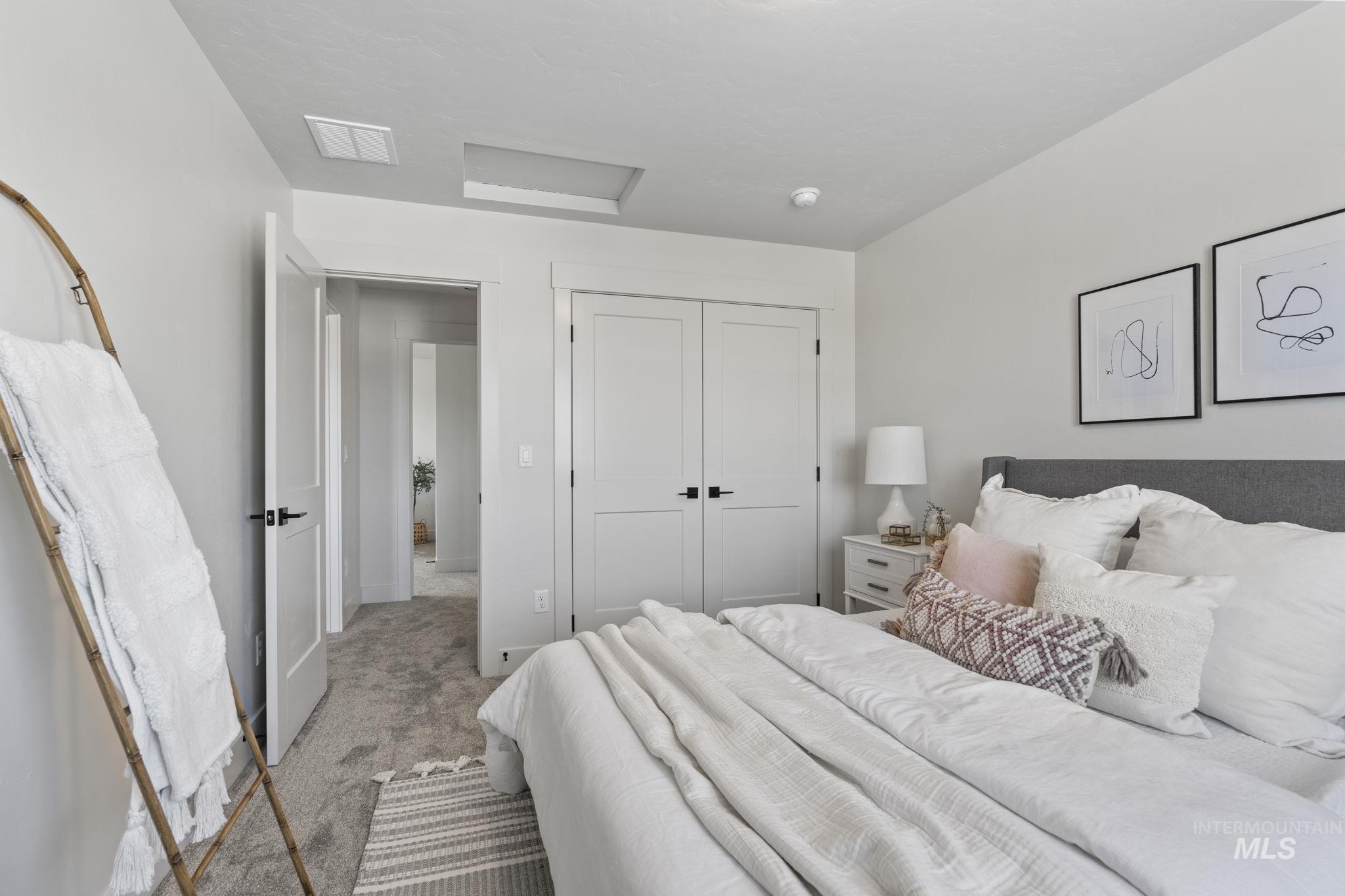 Bedroom with attic access, carpet, and a closet