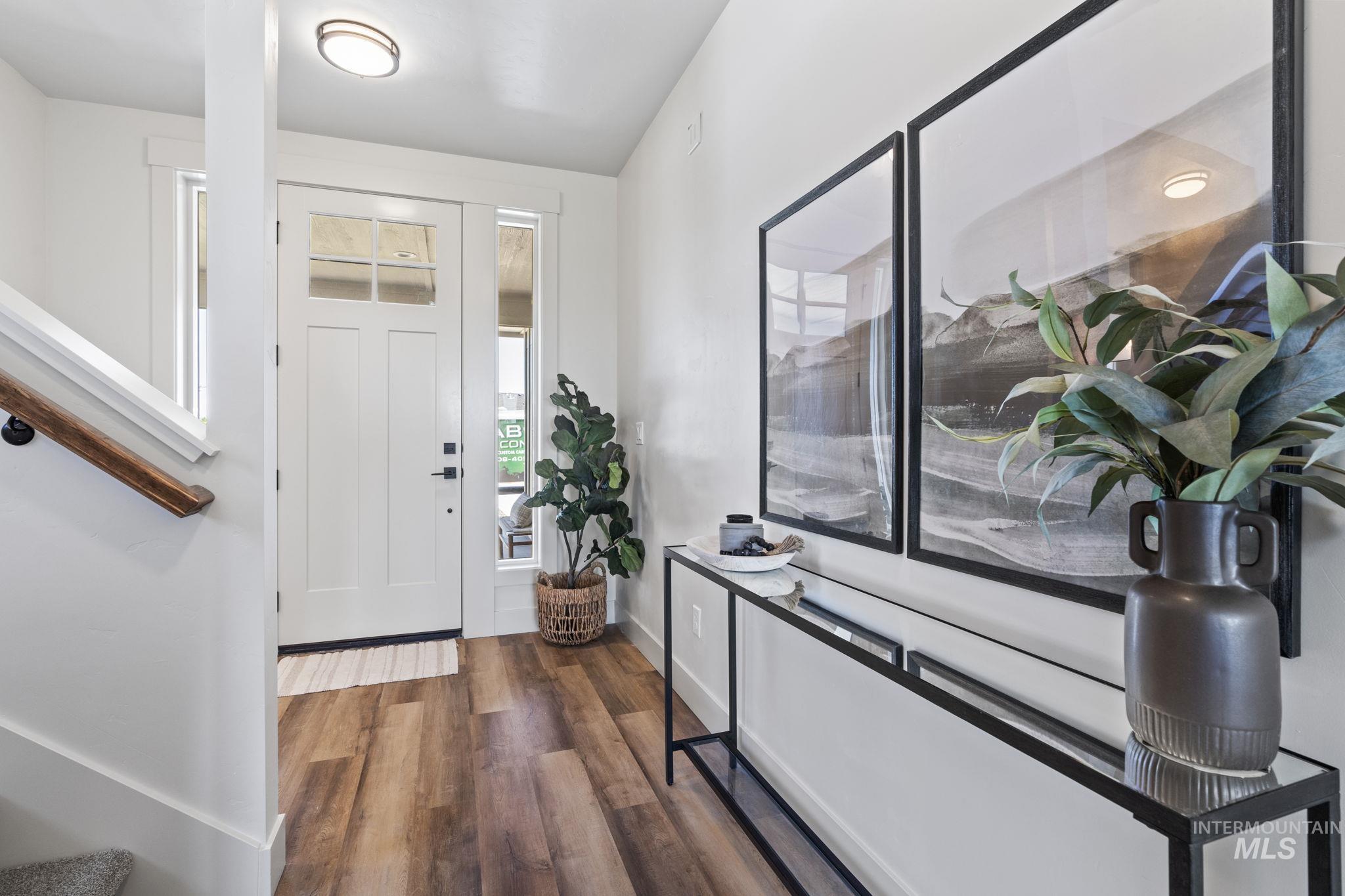Foyer entrance with dark wood-style floors and stairway