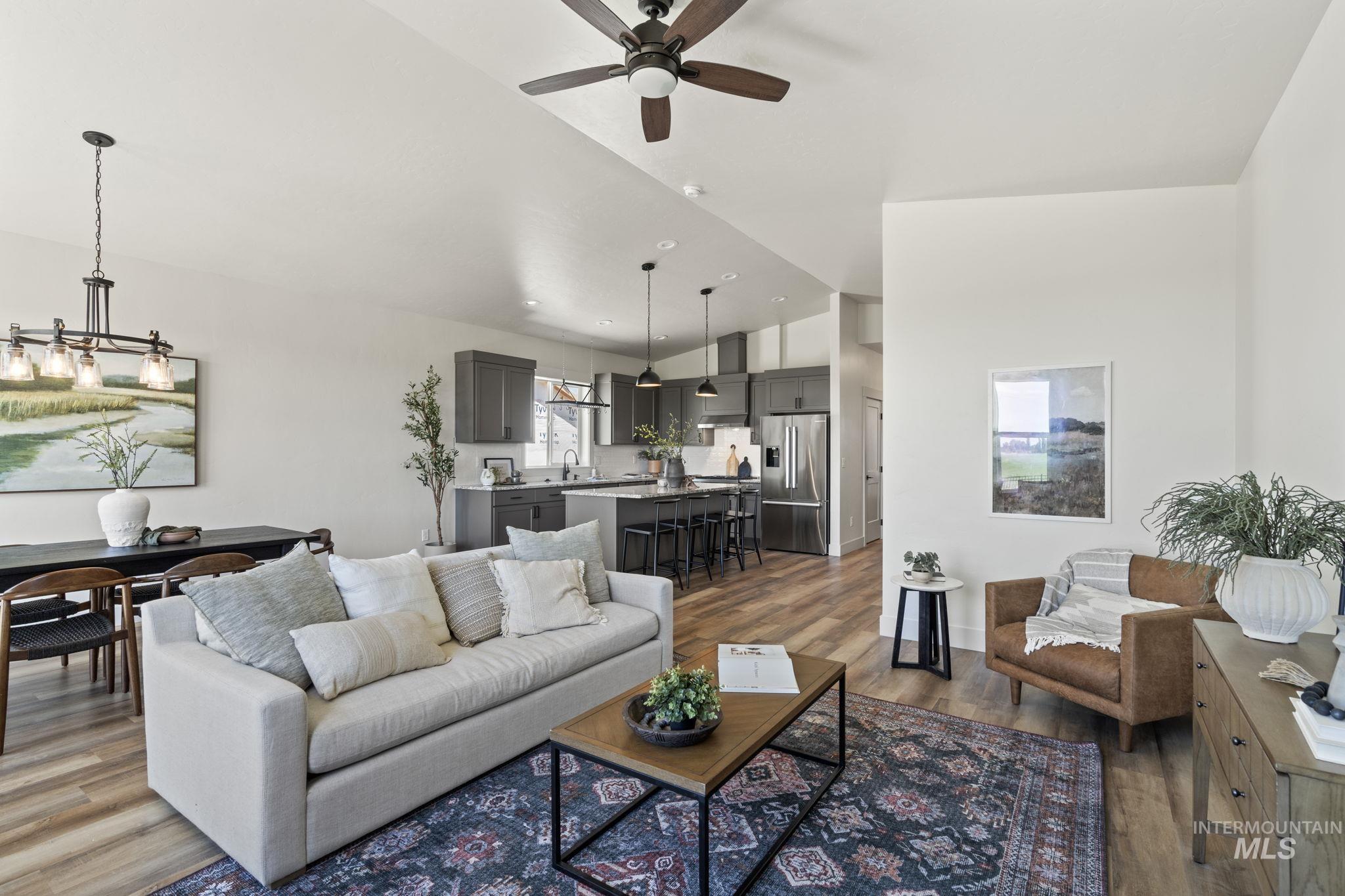 Living area with dark wood-type flooring, vaulted ceiling, and ceiling fan