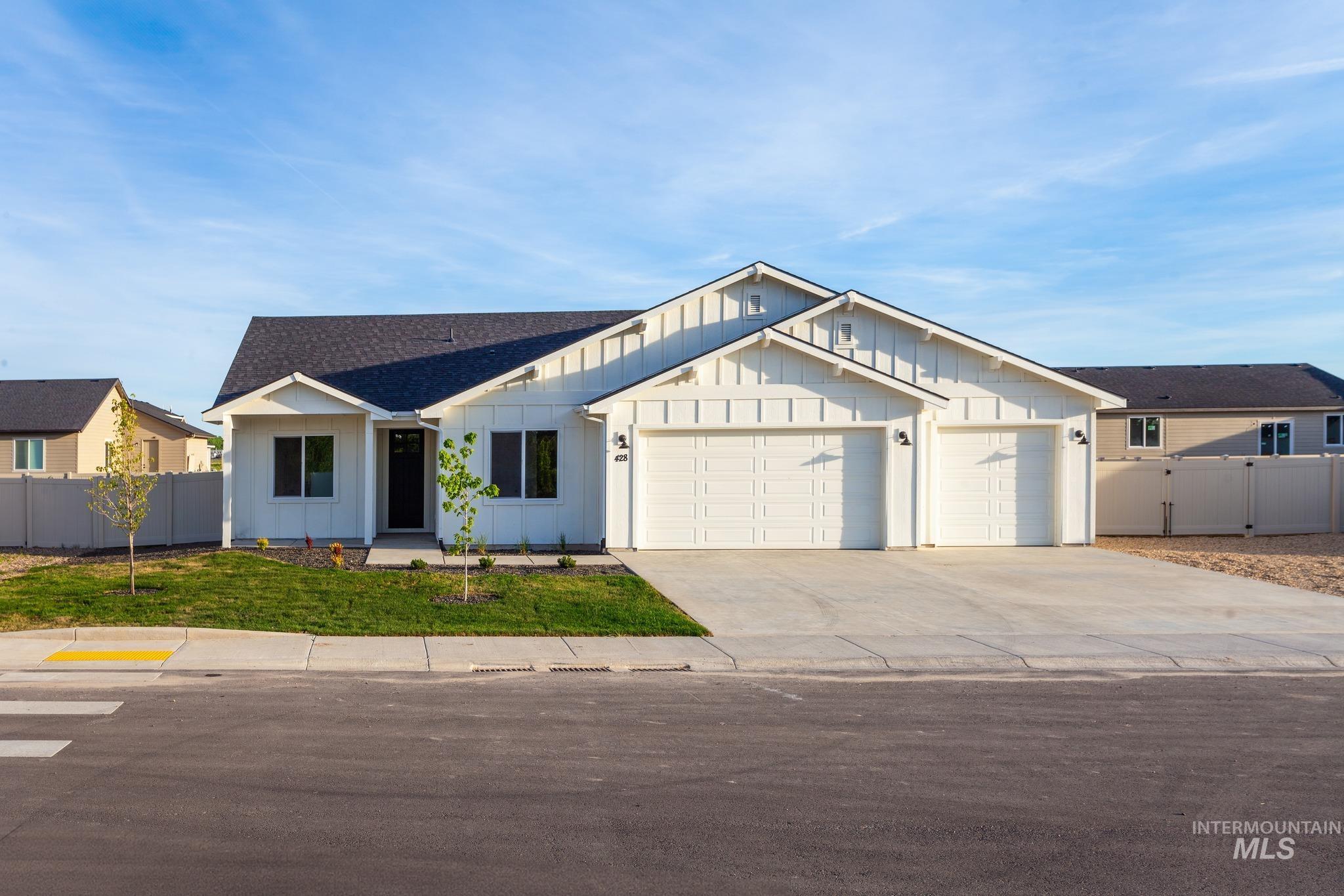 Modern farmhouse featuring board and batten siding, driveway, a garage, and roof with shingles