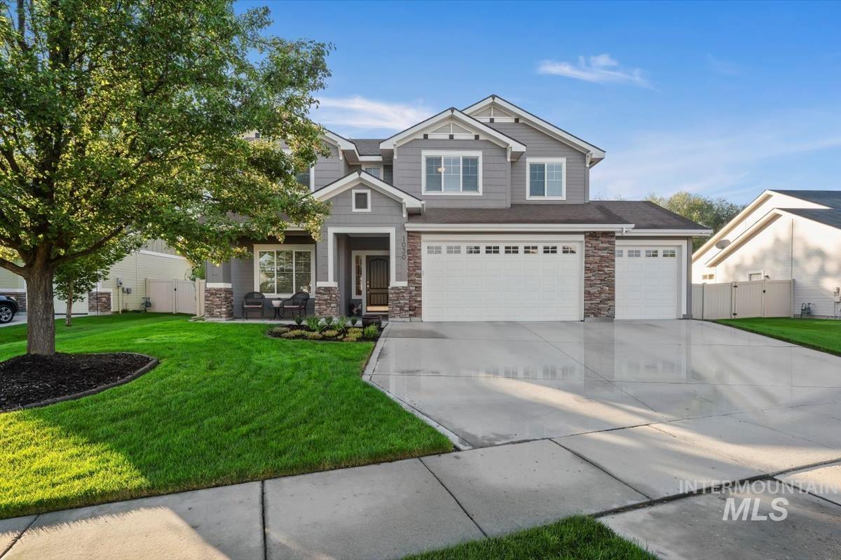 Craftsman inspired home with concrete driveway, a front lawn, stone siding, and a garage