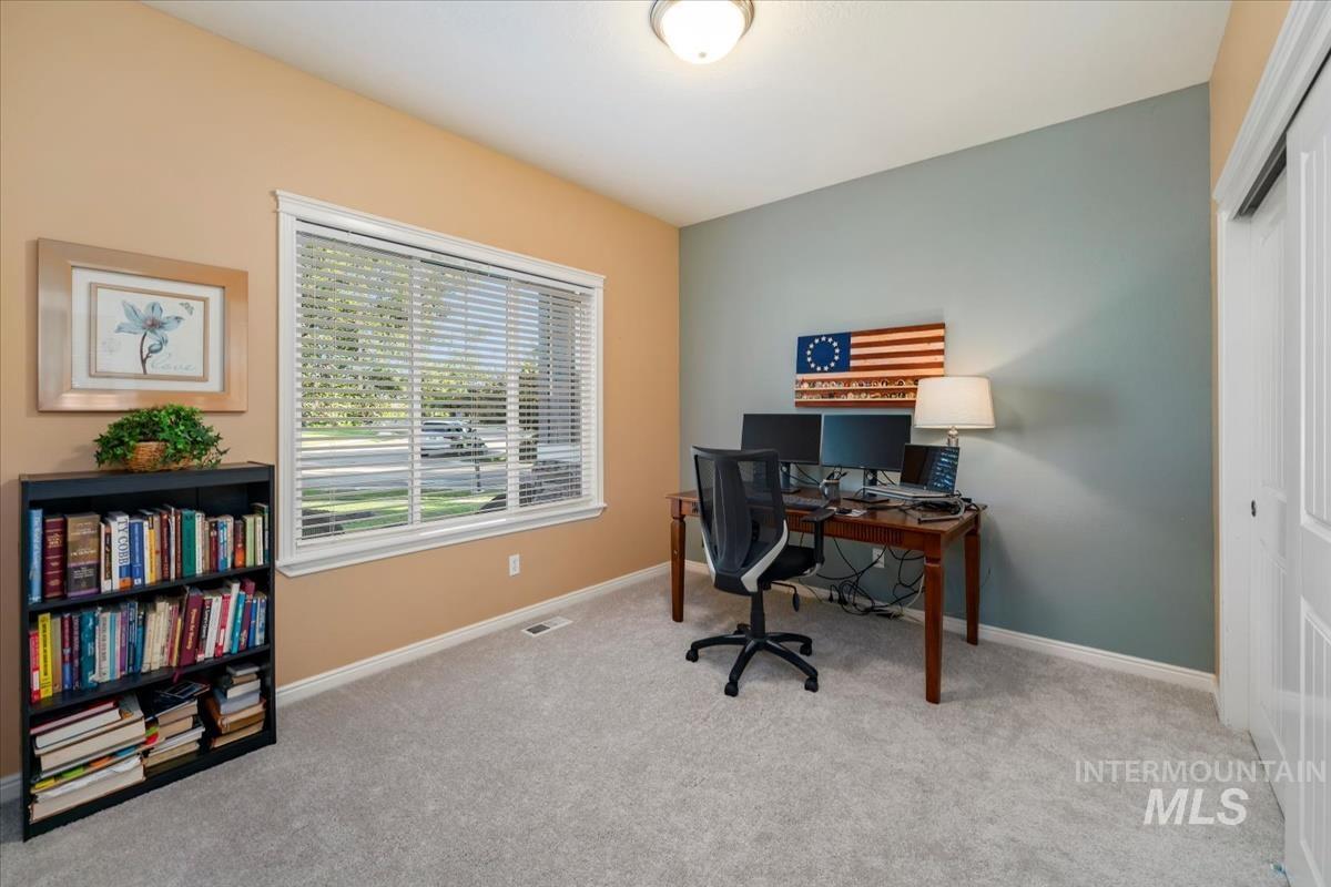 Carpeted home office featuring baseboards