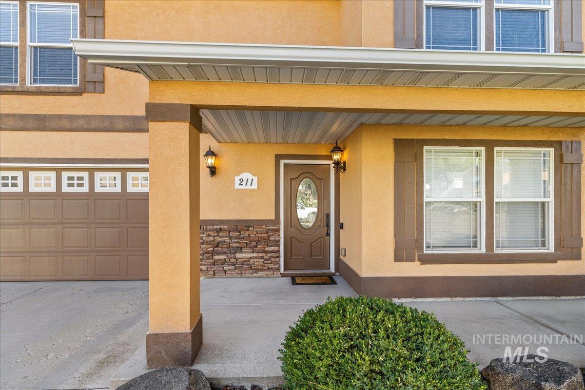 Property entrance featuring a porch and stucco siding