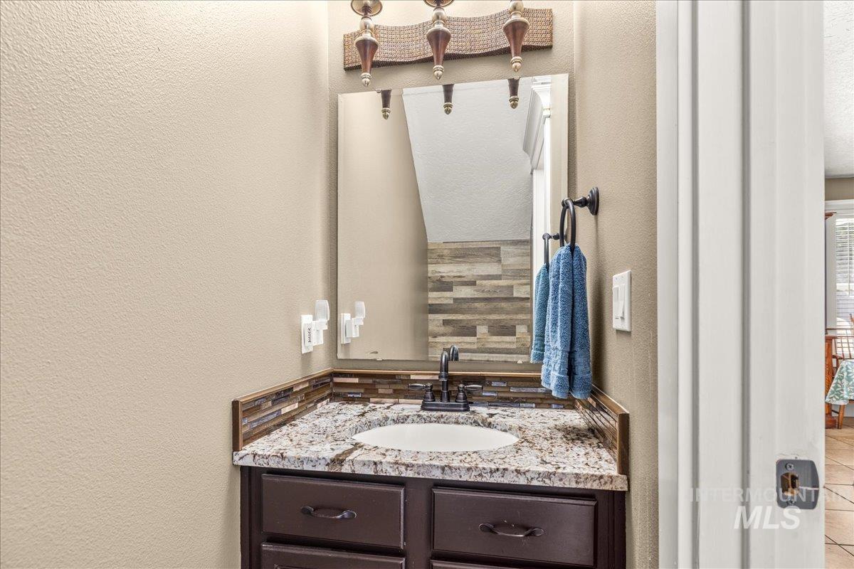 Bathroom featuring a textured wall and vanity