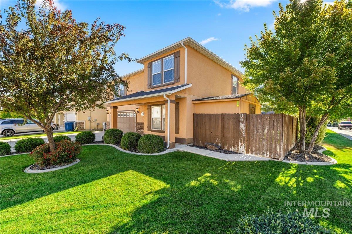 Traditional-style home with stucco siding, a garage, and covered porch
