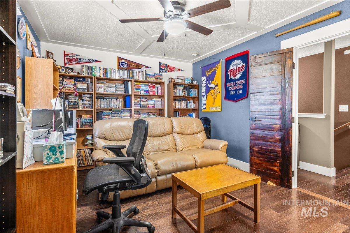 Office space with wood finished floors, a ceiling fan, and a textured ceiling