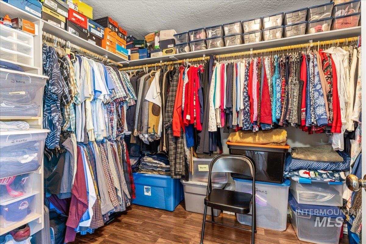 Spacious closet featuring dark wood-style floors