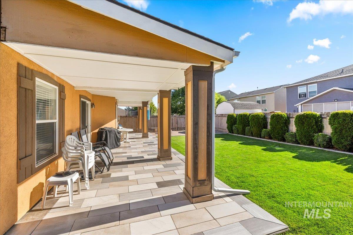 Fenced backyard featuring a patio and grilling area
