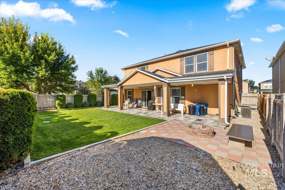 Rear view of property with a patio, a fenced backyard, stucco siding, and a fire pit