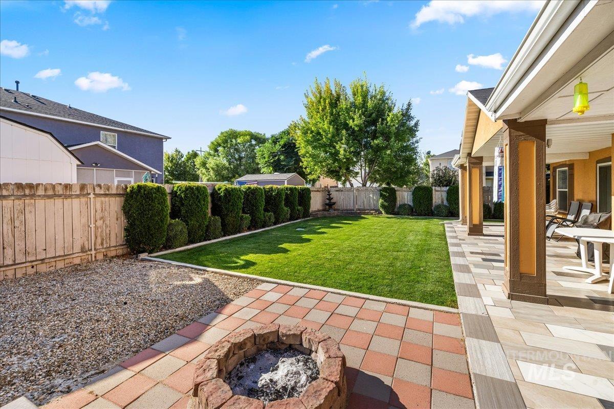 Fenced backyard with an outdoor fire pit and a patio