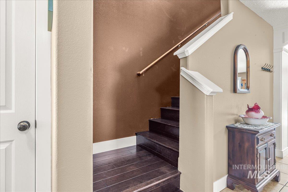 Stairs featuring wood finished floors and a textured wall