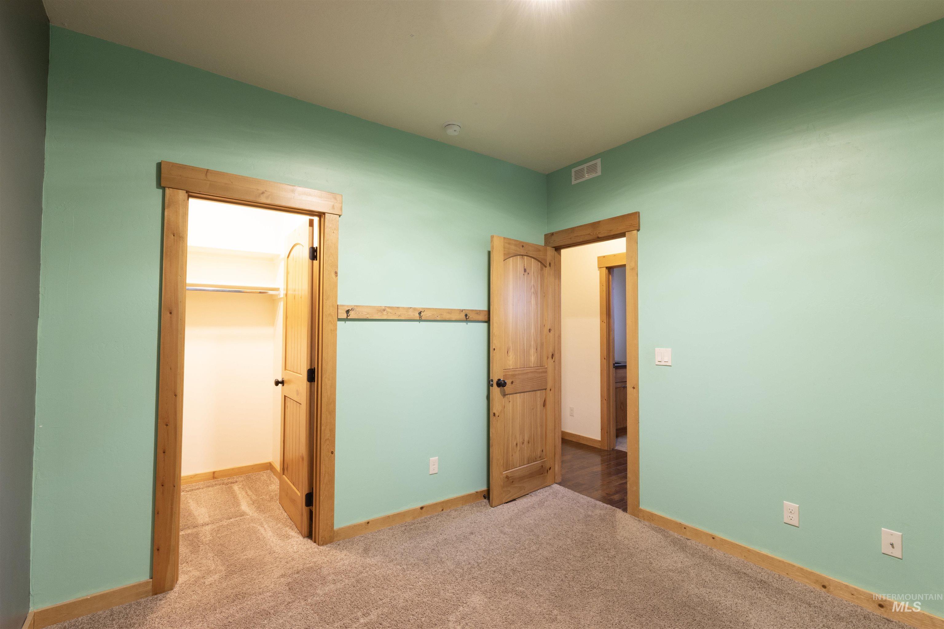 Unfurnished bedroom with carpet floors and a walk in closet