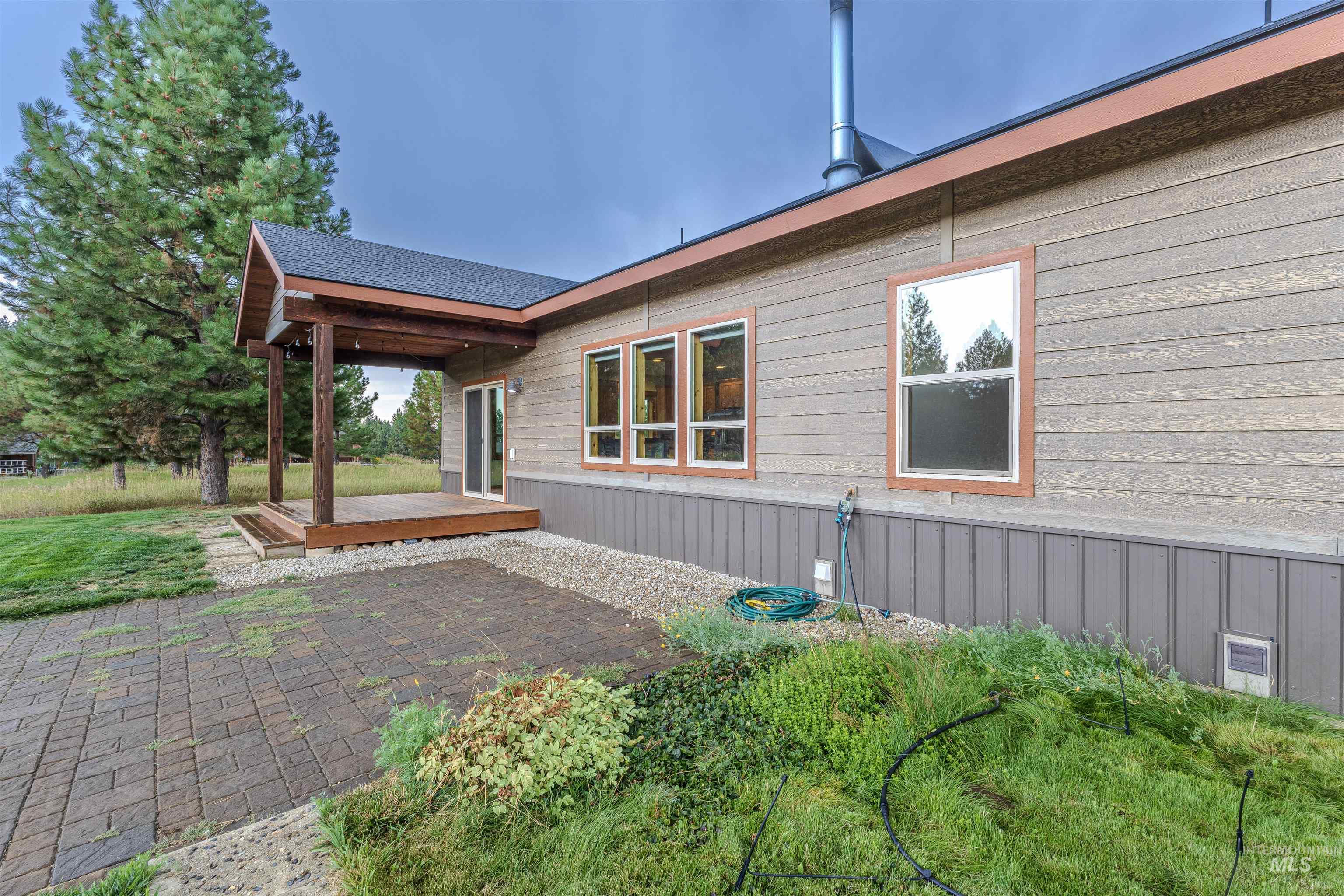 View of side of property featuring a wooden deck and a patio area