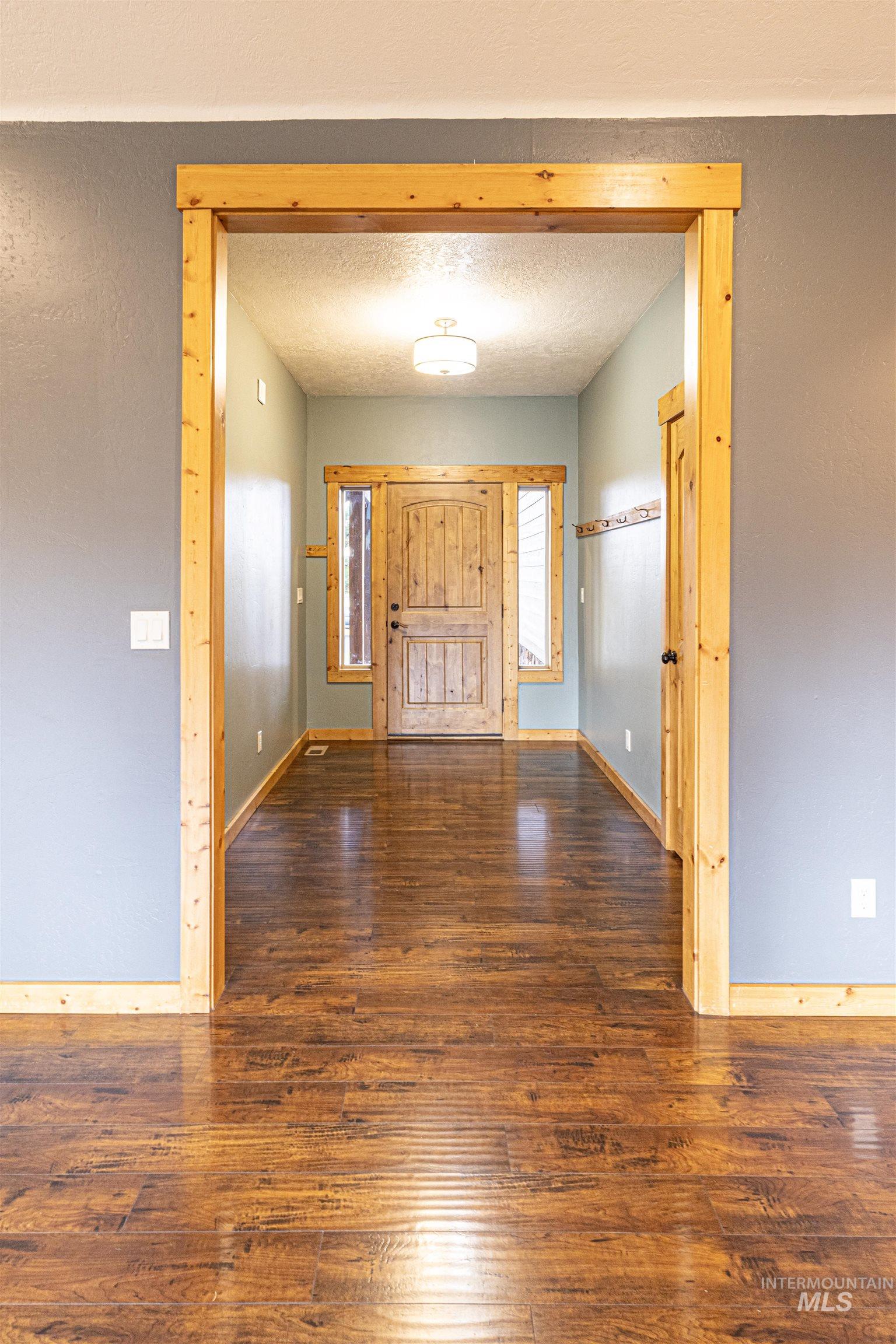 Foyer entrance with dark wood finished floors and a textured ceiling