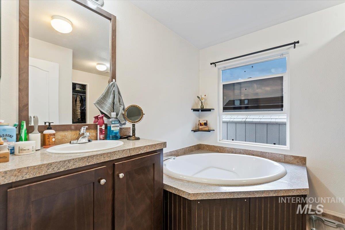 Full bath featuring a garden tub and vanity