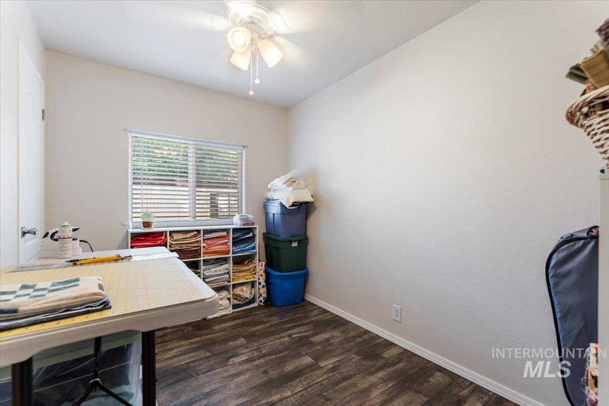 Office featuring dark wood-style floors and ceiling fan