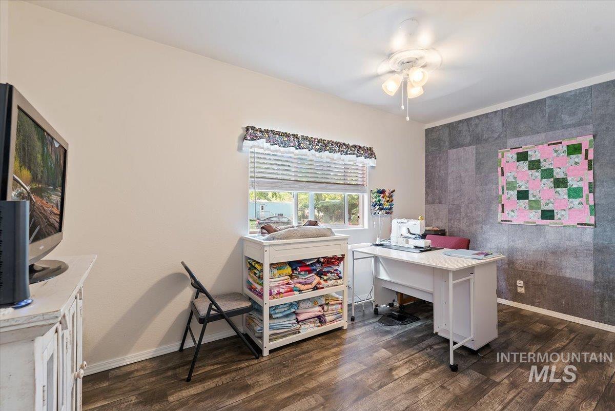 Office with dark wood-style flooring and an accent wall
