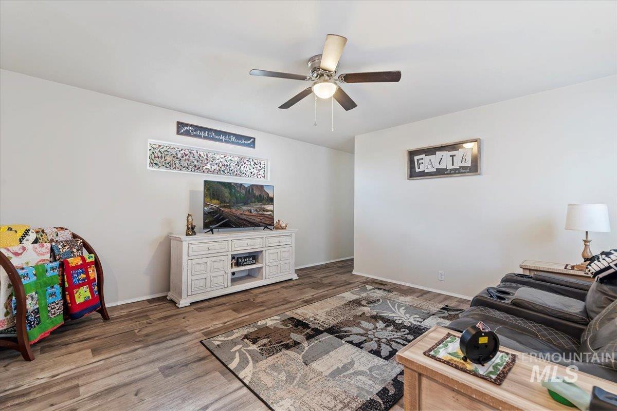 Living room featuring wood finished floors and a ceiling fan