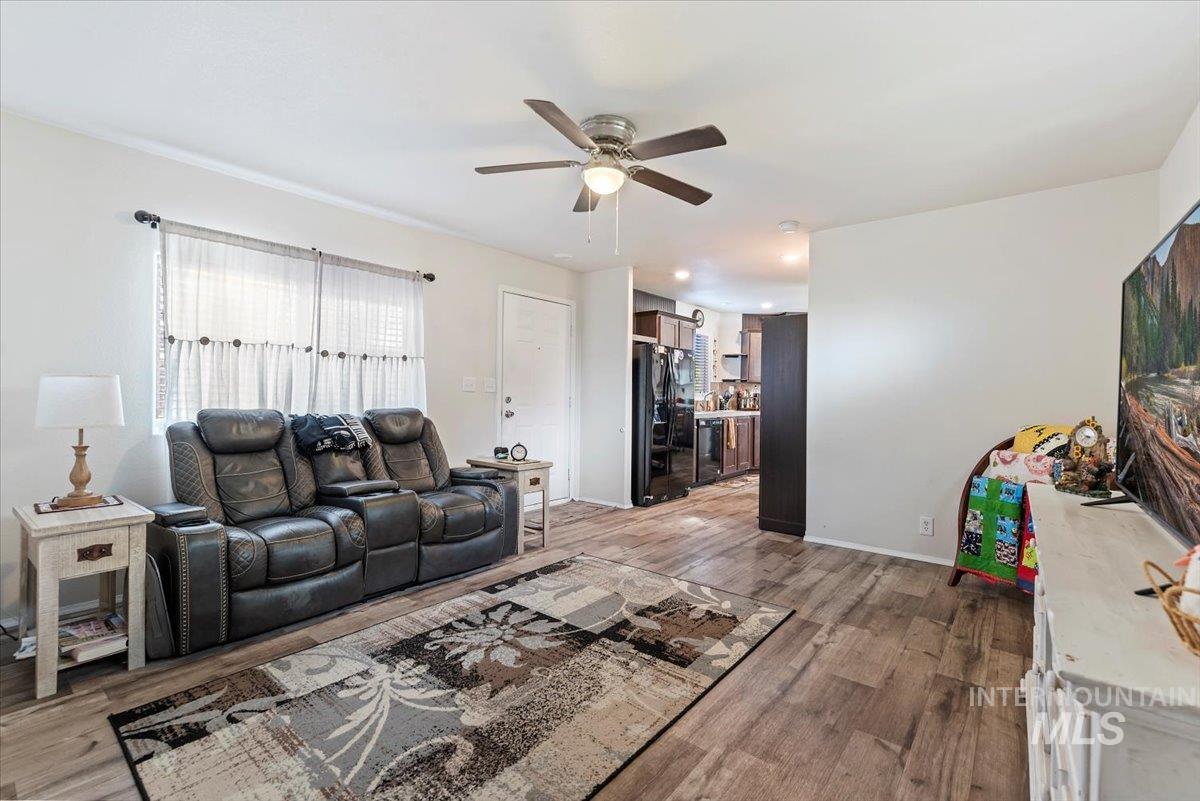 Living room with light wood-style floors and ceiling fan