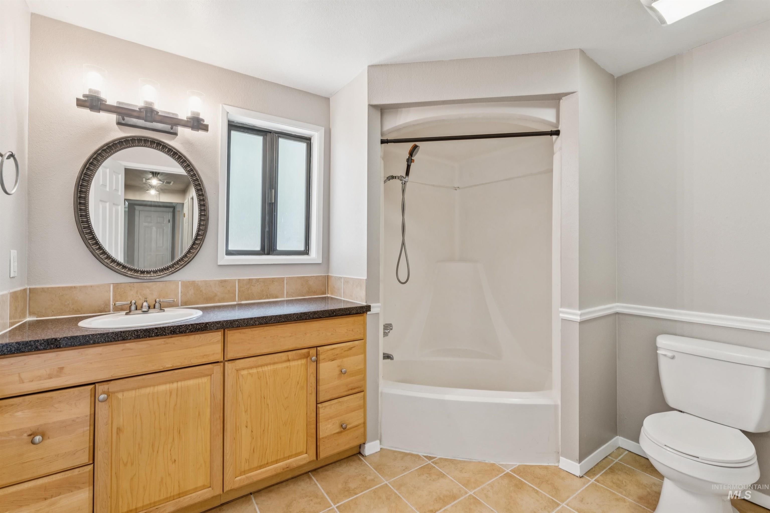 Full bath with light tile patterned floors, shower / tub combination, and vanity