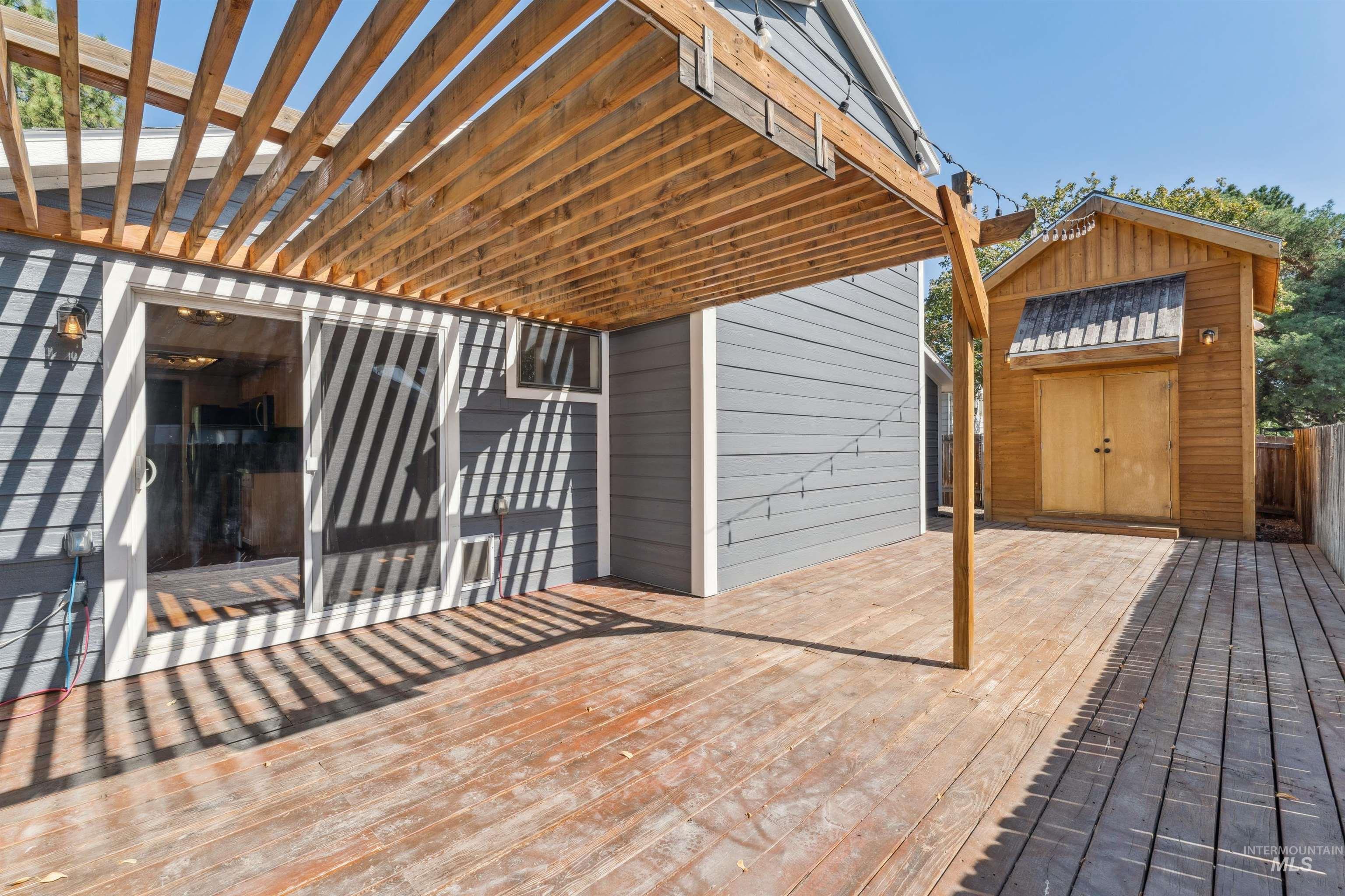 Wooden terrace featuring a storage unit