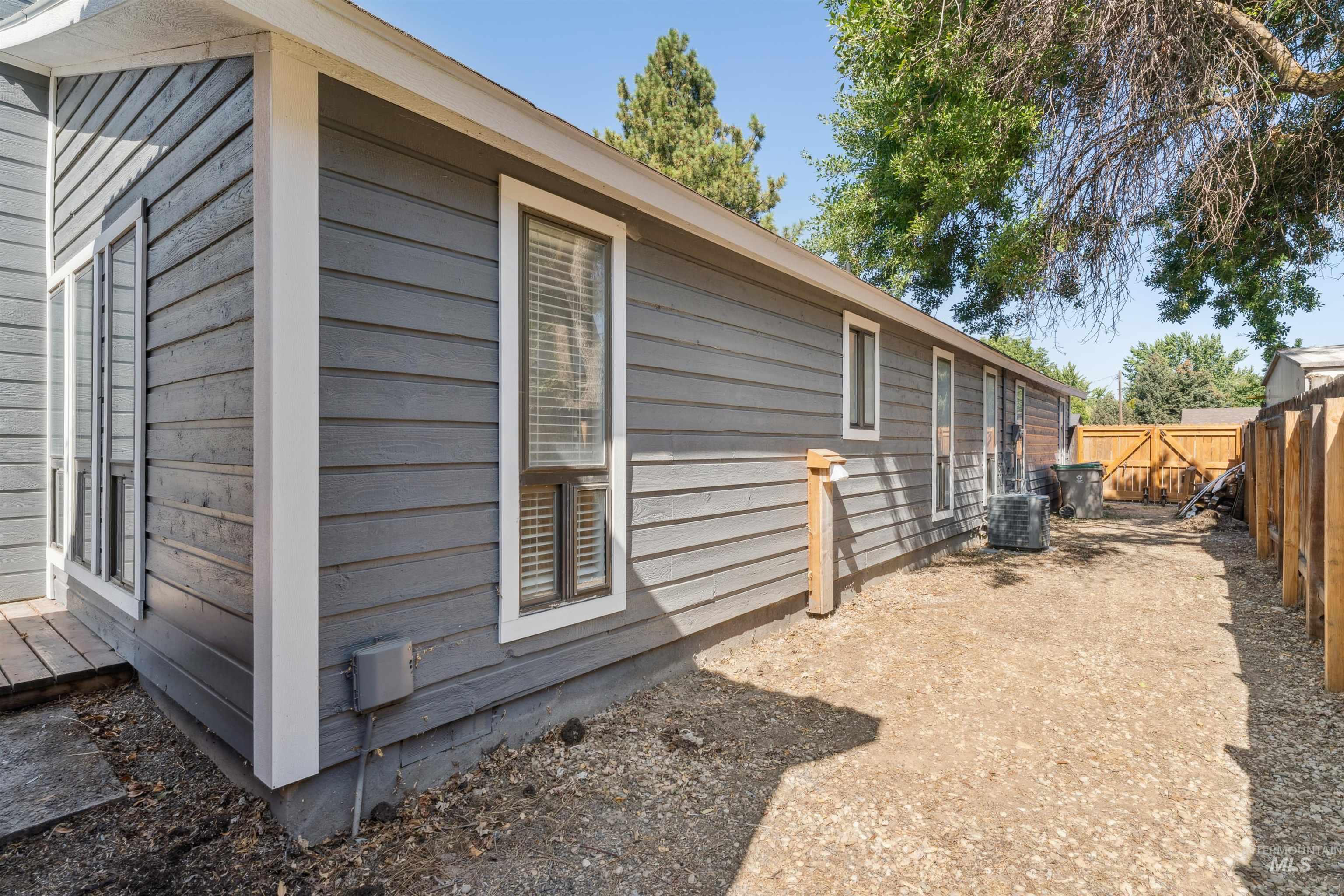 View of side of home with a fenced backyard and a cooling unit
