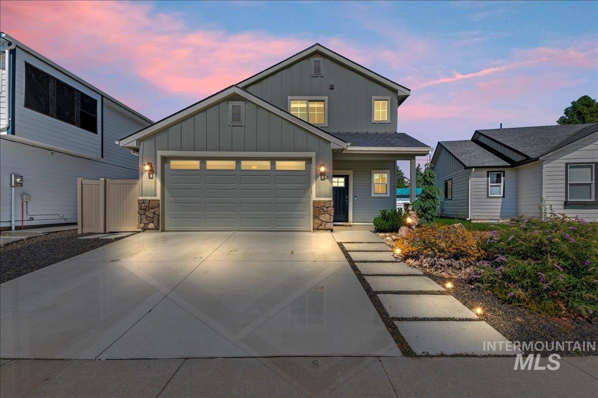 View of front facade featuring stone siding, board and batten siding, and concrete driveway