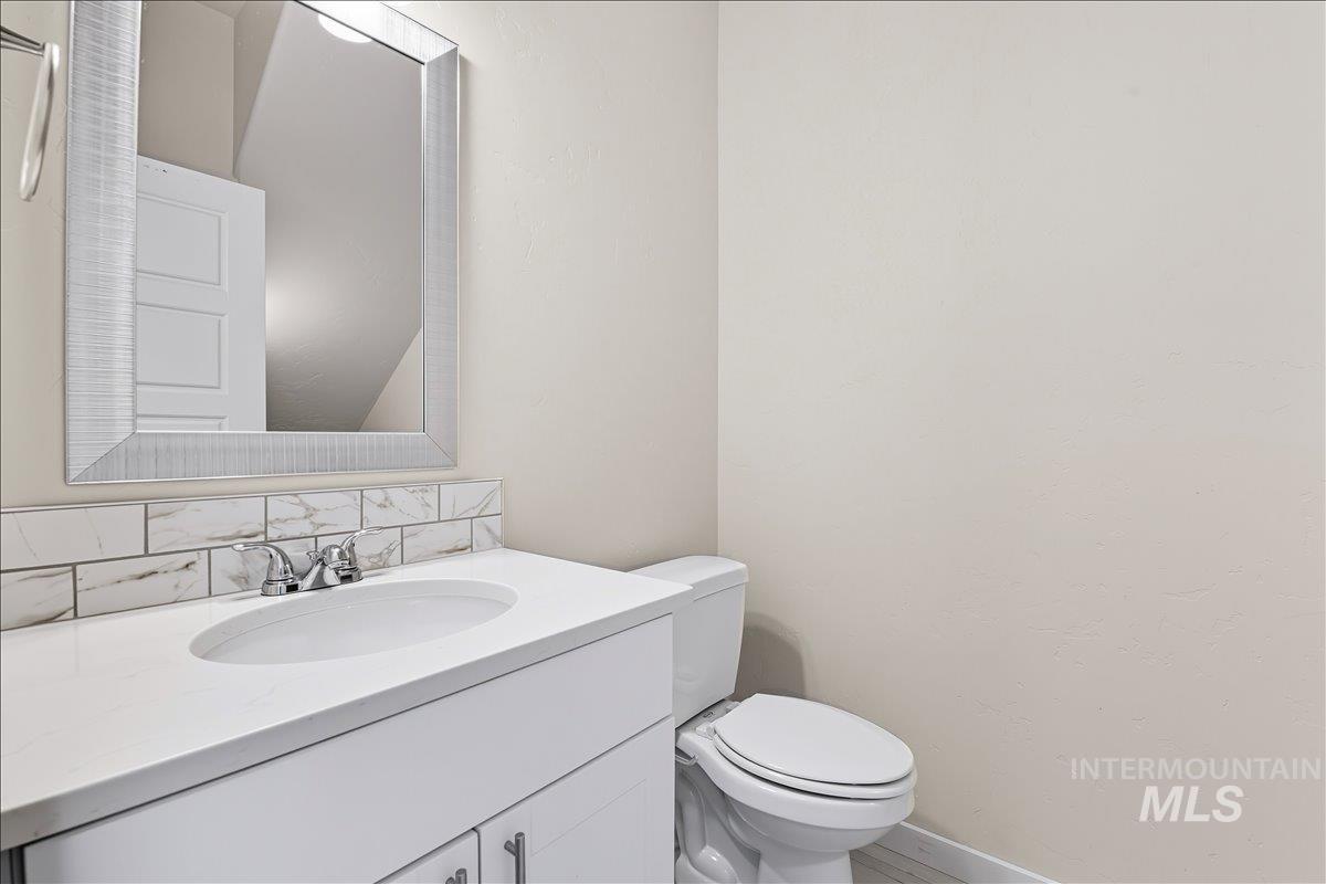 Bathroom with vanity and tasteful backsplash