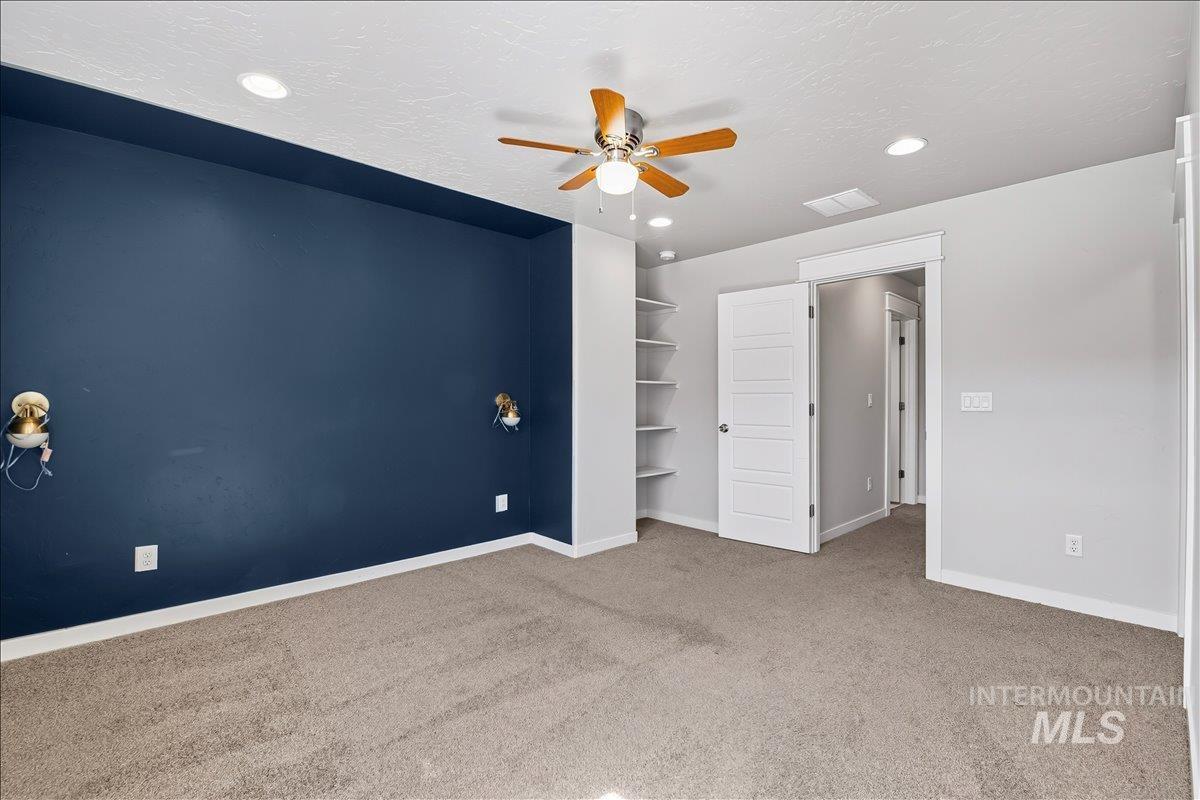 Unfurnished bedroom with a textured ceiling, light carpet, a ceiling fan, and recessed lighting