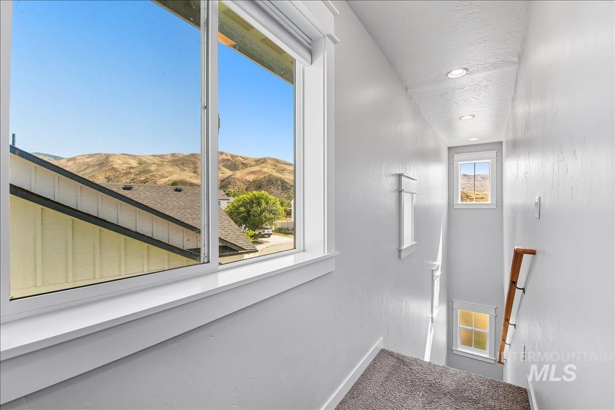 Staircase with a mountain view, carpet flooring, and recessed lighting