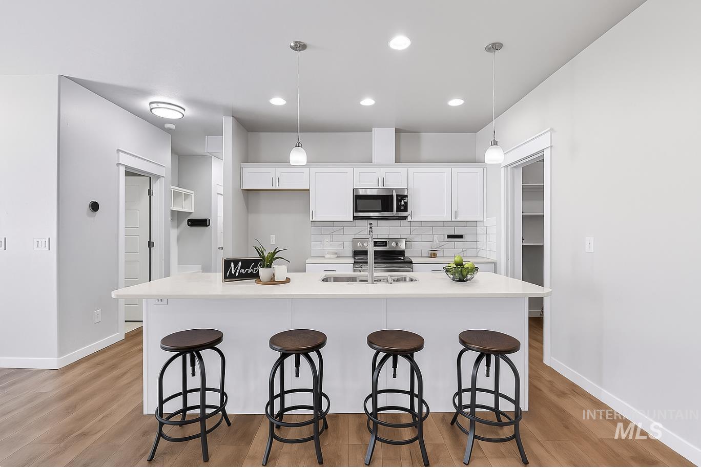 Kitchen with white cabinetry, decorative backsplash, pendant lighting, light wood-style flooring, and recessed lighting