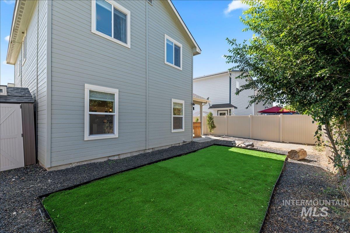 Rear view of property with a fenced backyard and an outbuilding