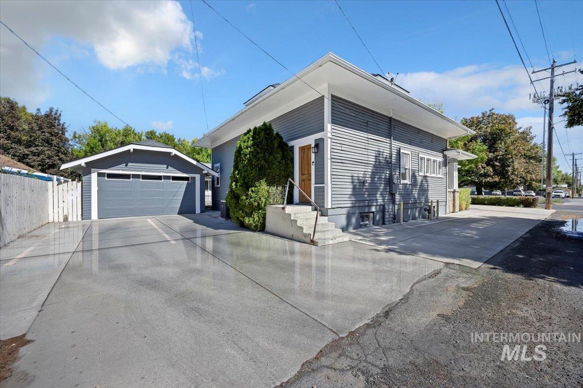 View of property exterior featuring a detached garage and an outdoor structure