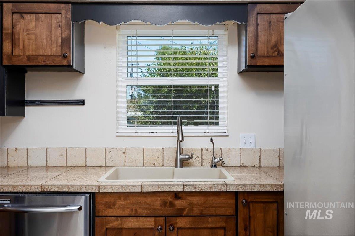 Kitchen featuring stainless steel appliances and brown cabinetry