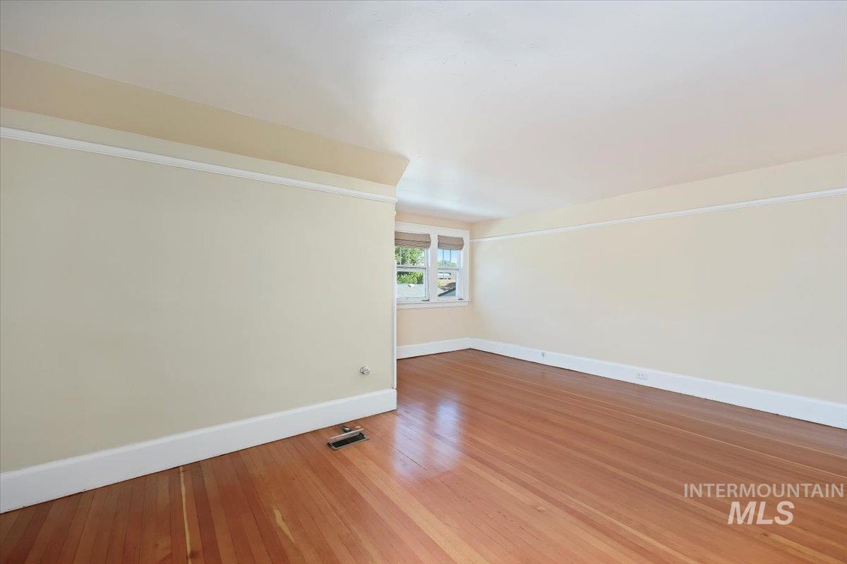 Spare room featuring light wood-type flooring and baseboards