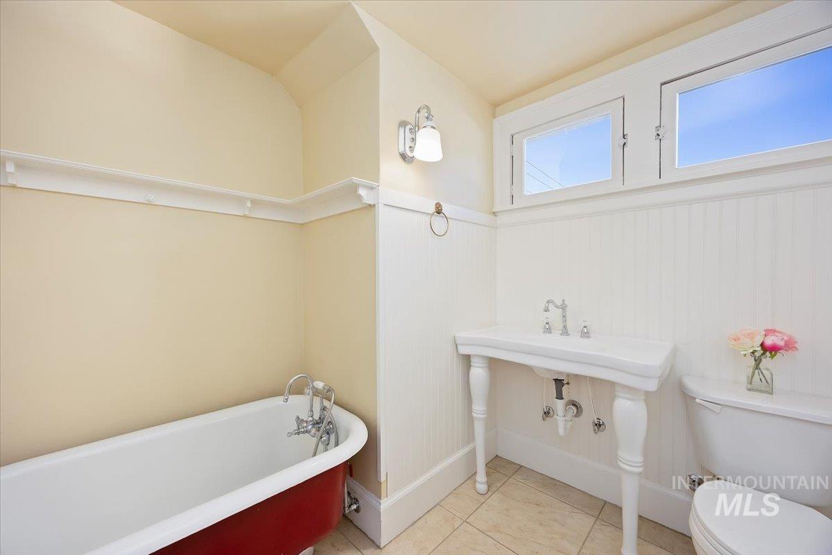 Full bath featuring a freestanding tub and light tile patterned floors
