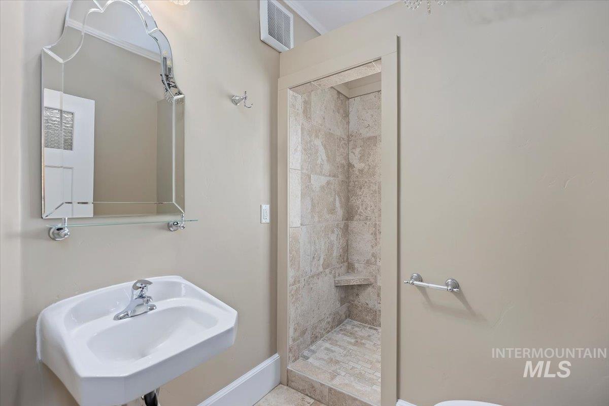 Full bathroom featuring a stall shower and a sink