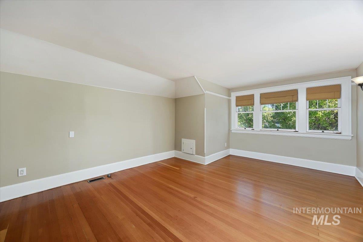 Bonus room with baseboards and light wood-style floors