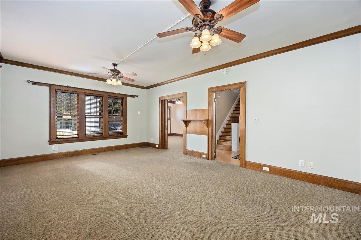 Carpeted spare room with ornamental molding and ceiling fan