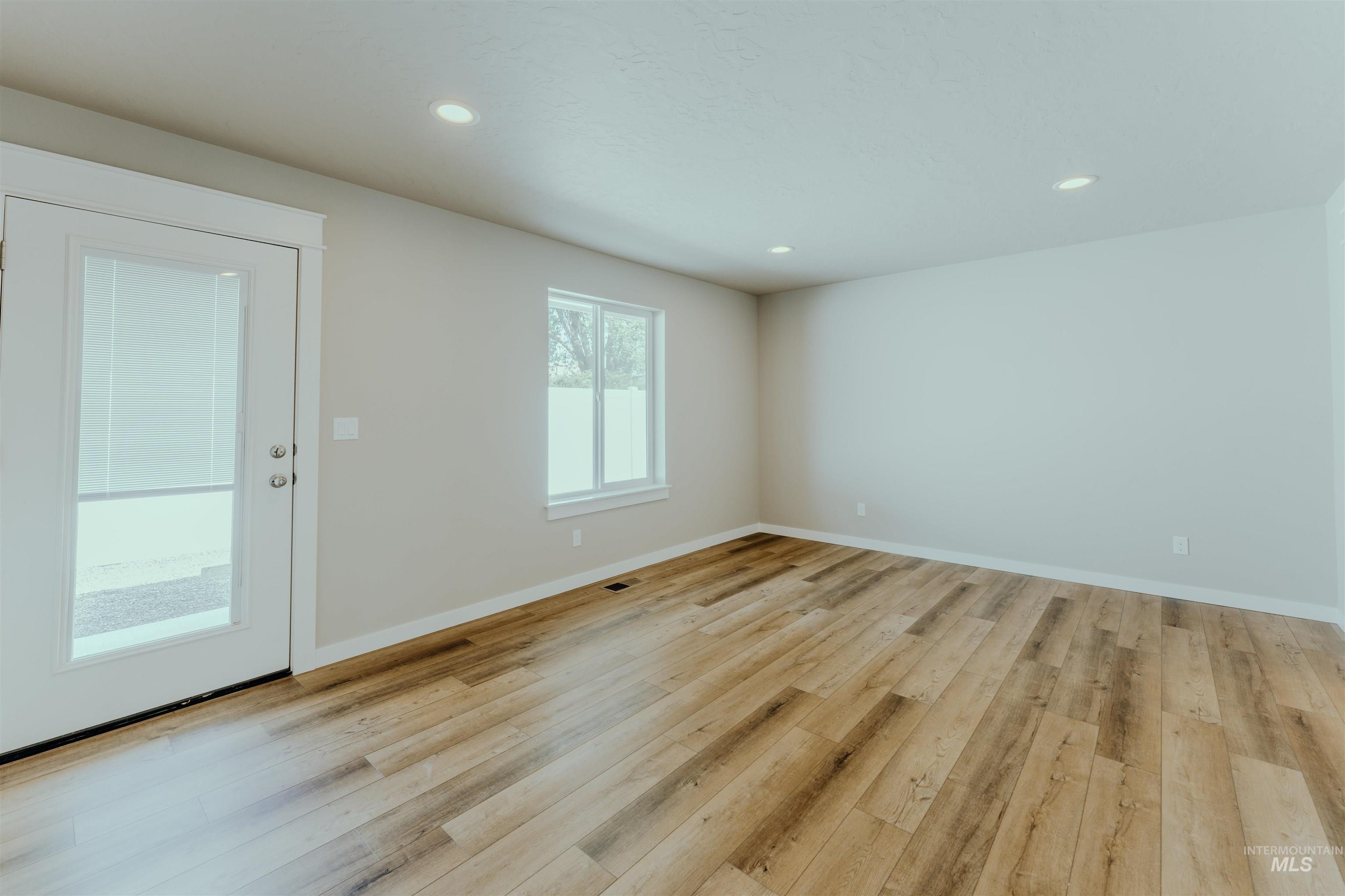 Empty room with recessed lighting and light wood-style floors