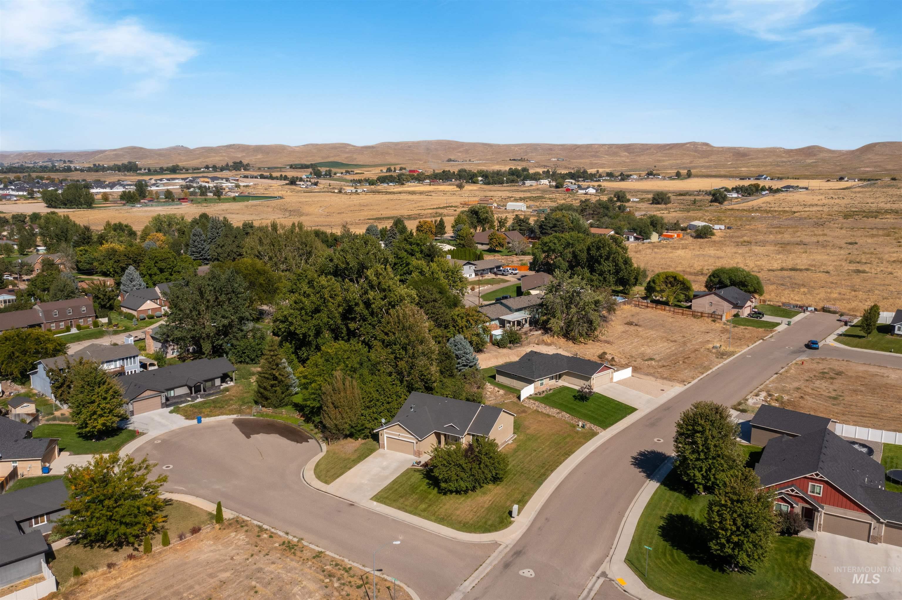 Aerial overview of property's location featuring mountains and nearby suburban area
