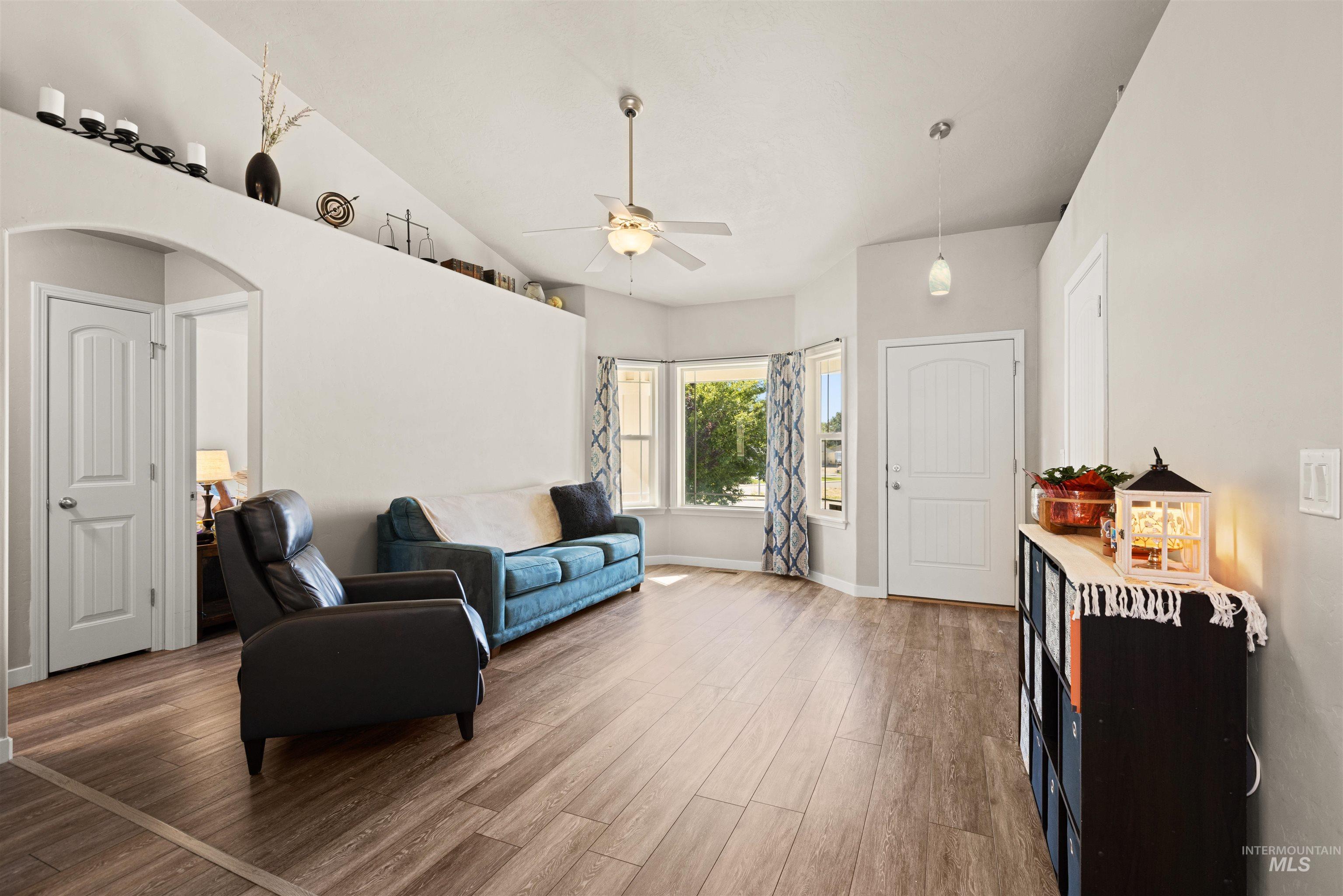 Sitting room with wood finished floors, arched walkways, and ceiling fan