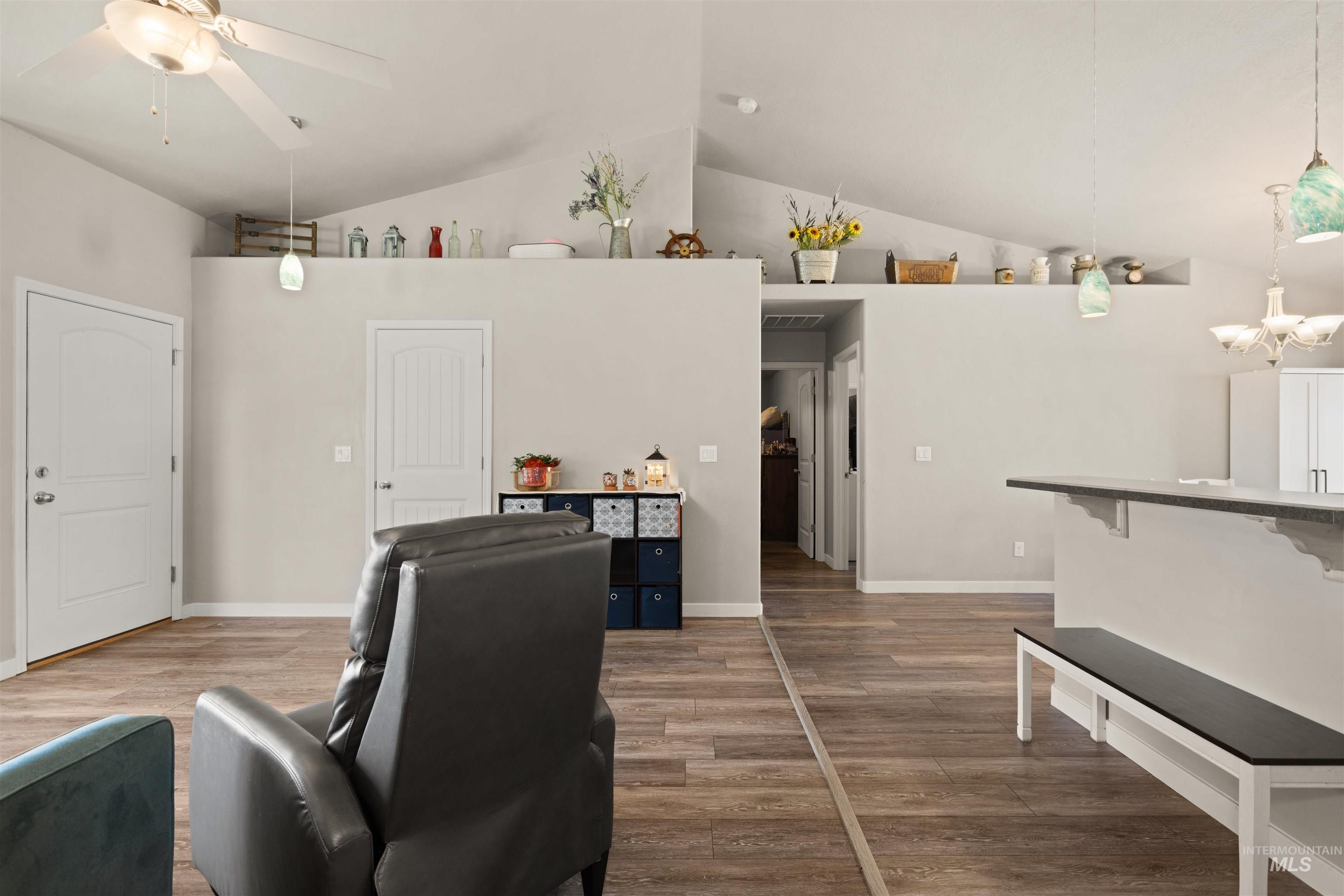 Living room featuring light wood-type flooring, ceiling fan, and high vaulted ceiling